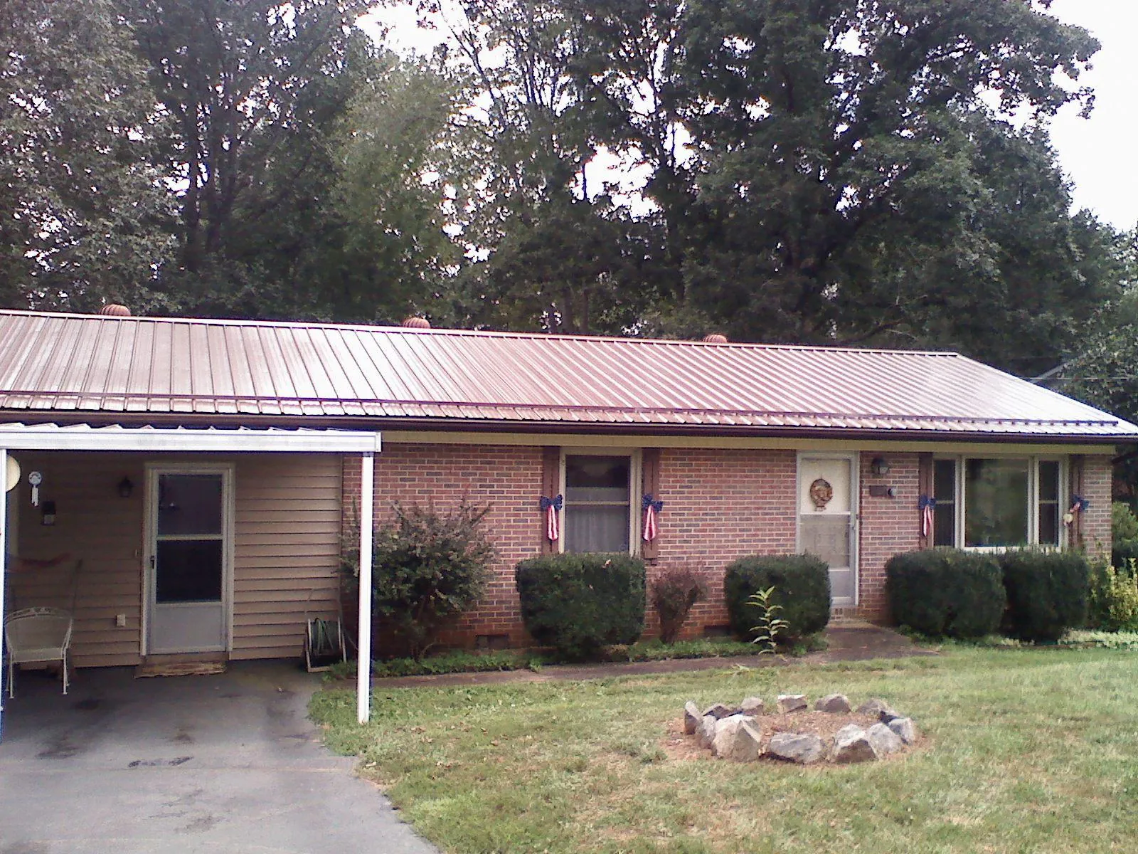 Bronze metal roof and carport on a brick ranch home — Roof Repair work by our crew in Big Indian