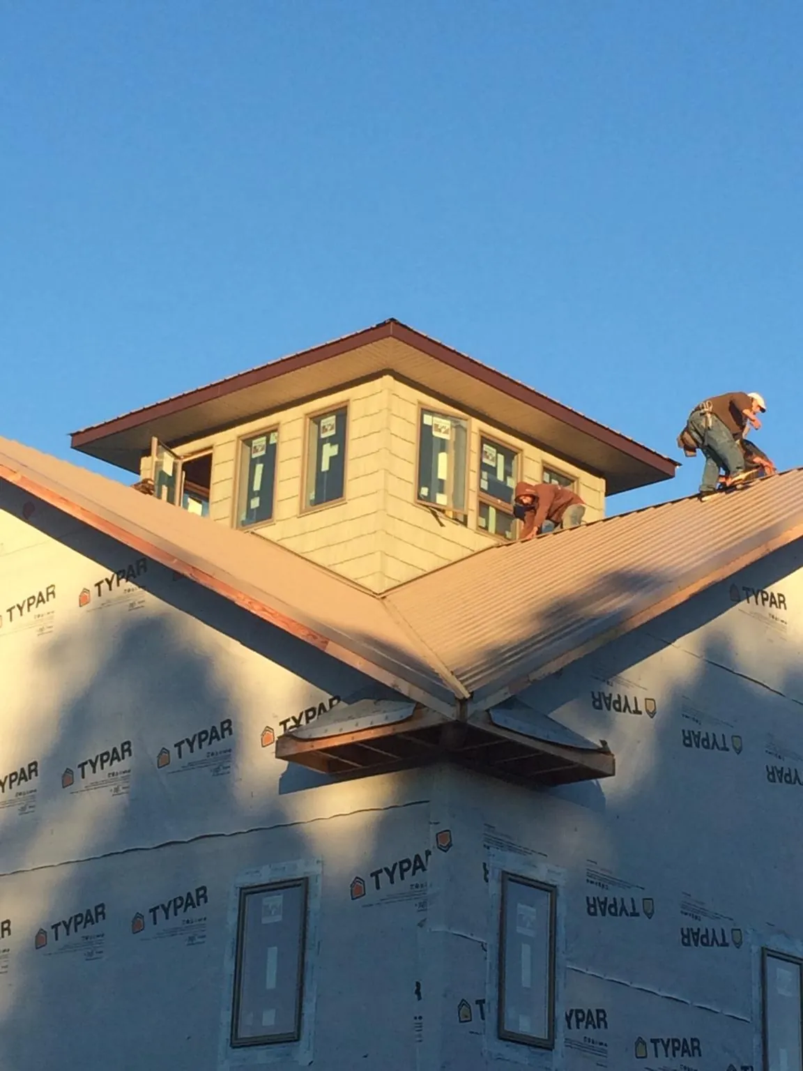 Roofers working around a rooftop cupola on a new metal roof at sunset — Roof Waterproofing in Big Indian by Roofing Brothers